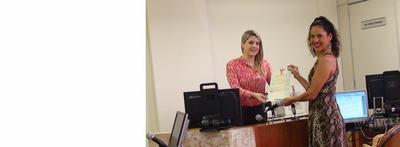 Imagem: Juíza Isabelle Lima entrega certificado de naturalização a professora