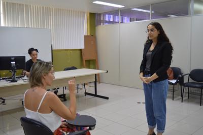 Michele (sentada) e Laura (em pé) fazem prova prática de Libras Imagem: Michele (sentada) e Laura (em pé) fazem prova prática de Libras